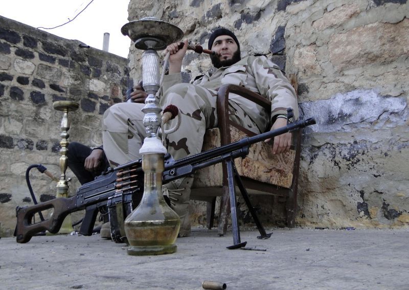 Combatente sírio coloca a arma em meio a um narguilé | Reuters/Mahmoud Hassano