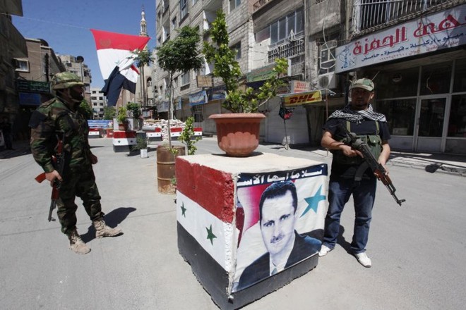 Soldados leais ao governo do ditador Bashar Assad fazem guarda em posto de controle na capital síria, Damasco | Alaa Al-Marjani/Reuters