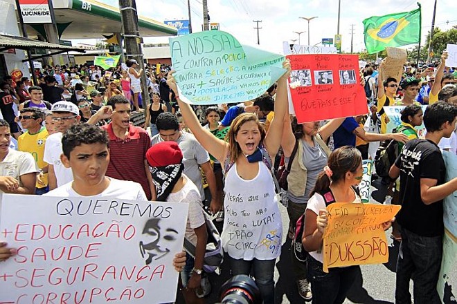 Manifestantes portam cartazes nas proximidades da Arena Castelão |