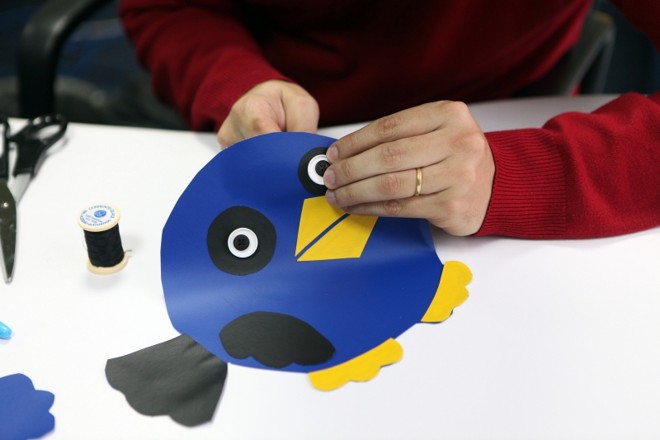 4.º fixe os olhos: Com um botão branco e outro preto, faça os olhos da gralha. Costure no tecido, passando a linha por todos os furinhos dos botões | 