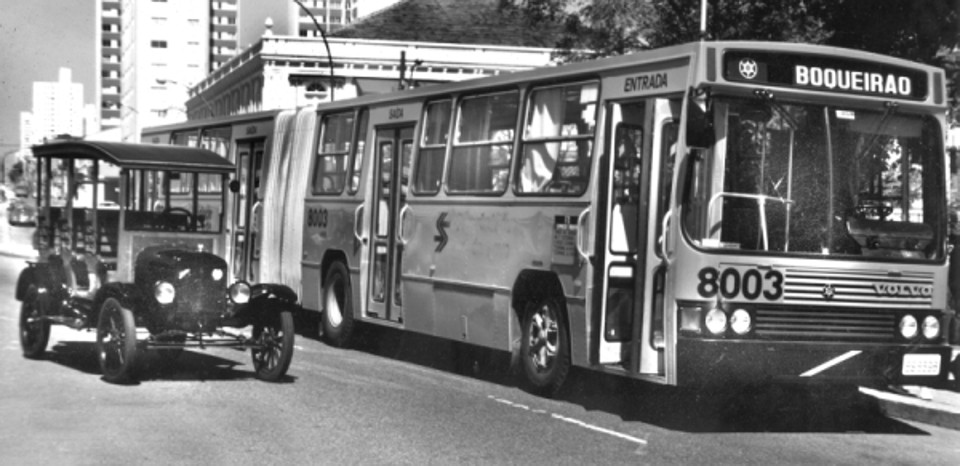 Foto do protótipo do primeiro ônibus de Curitiba junto ao moderno articulado em foto feita por ocasião do centenário da inauguração dos bondes de mulas, em 1987 | Acervo Cid Destafani