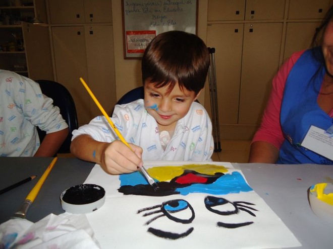 Criança confeccionando trabalho durante oficina. Desenhos estão expostos na sede da ONU, em Nova York | 