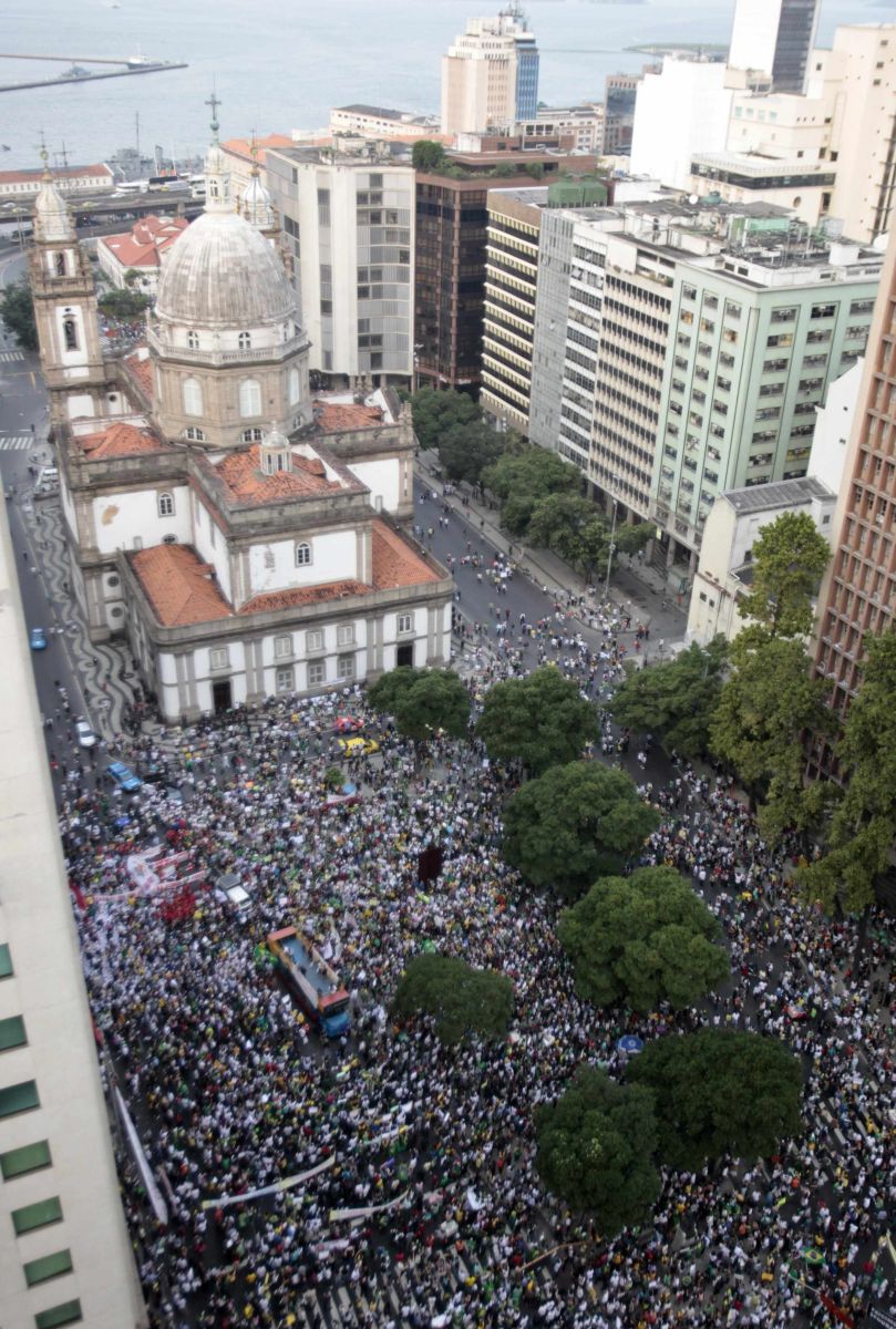 Em ruas próximas à igreja, alguns jovens ainda terminam de confeccionar cartazes e de pintar seus rostos com as cores verde e amarela | Sergio Moraes / REUTERS
