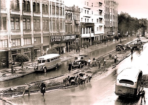 Avenida João Pessoa, atual Luiz Xavier, em 1941, quando eram retirados os trilhos dos bondes. Na foto, dois ônibus da linha Alto da XV e, no Cine Avenida, passava E o Vento Levou | Acervo Cid Destefani