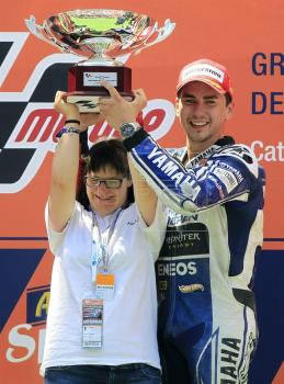 O piloto de MotoGP Jorge Lorenzo (Yamaha), celebra a sua vitória junto com Anna Vives, criadora da tipografia do capacete usado por ele nesta prova | EFE/Andreu Dalmau