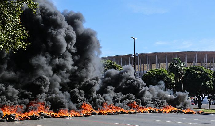 Manifestantes atearam fogo em pneus em frente ao Estádio Mané Garrincha na véspera da abertura da Copa das Confederações | Vanessa Carvalho / Folhapress
