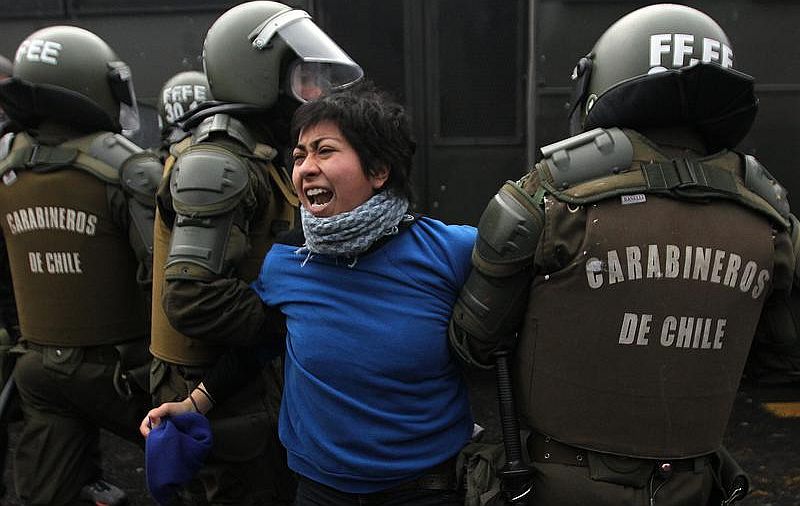 Manifestante é detida pela polícia chilena em Santiago durante protesto de estudantes com o apoio de centrais sindicais do país | EFE/MARIO RUIZ