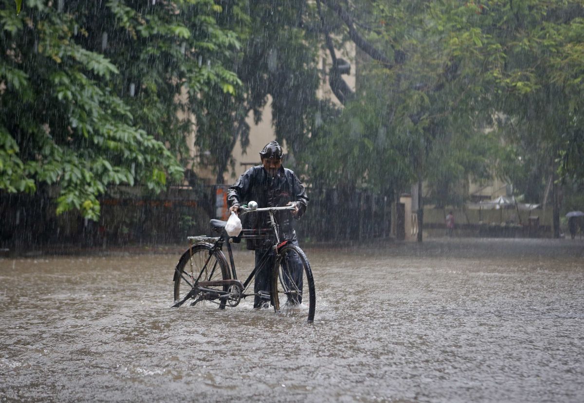 Homem empurra bicicleta em meio às chuvas de monção em Mumbai, na Índia | Reuters/Danish Siddiqui