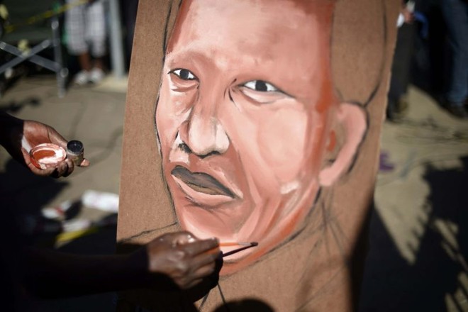 Homem pinta retrato do ex-presidente sul-africano Nelson Mandela, em Pretória | Dylan Martinez/Reuters