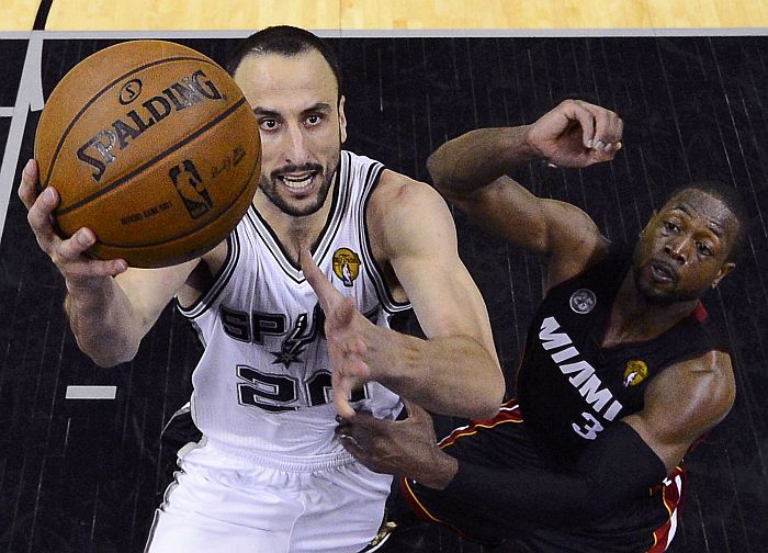 Manu Ginóbili, destaque da vitória que deixou o Spurs perto do título, divide a bola com Dwyne Wade, do Miami Heat | John G. Mabanglo / Reuters
