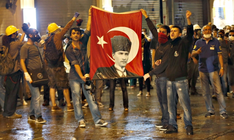 Manifestantes antigoverno carregam uma bandeira com o rosto do fundador da Turquia, Mustafa Kemal Ataturk | Murad Sezer/Reuters