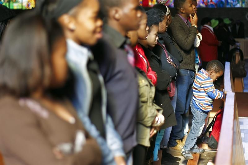 Congregados oram durante o culto de domingo na igreja Regina Mundi, em Soweto, um ponto de inflamação durante a luta anti-apartheid, em Joanesburgo, na África do Sul | Dai Kurokawa/EFE/EPA