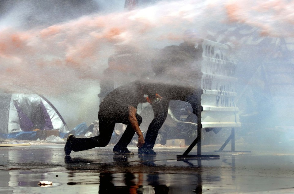 Manifestantes se protegem em uma barricada durante confronto com a polícia turca | Reuters/Yannis Behrakis