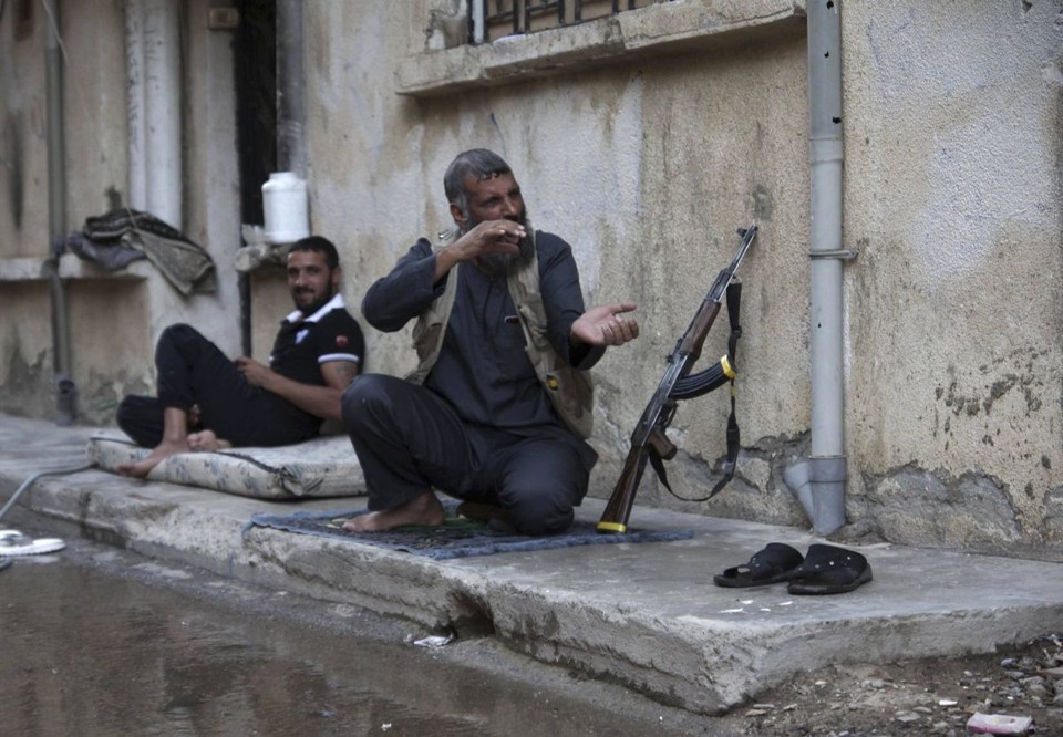 Rebelde sírio faz gestos enquanto se ajoelha em uma calçada da cidade de Deir al-Zor | Reuters/Khalil Ashawi