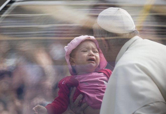 Criança chora enquanto é levantada para benção do papa | 