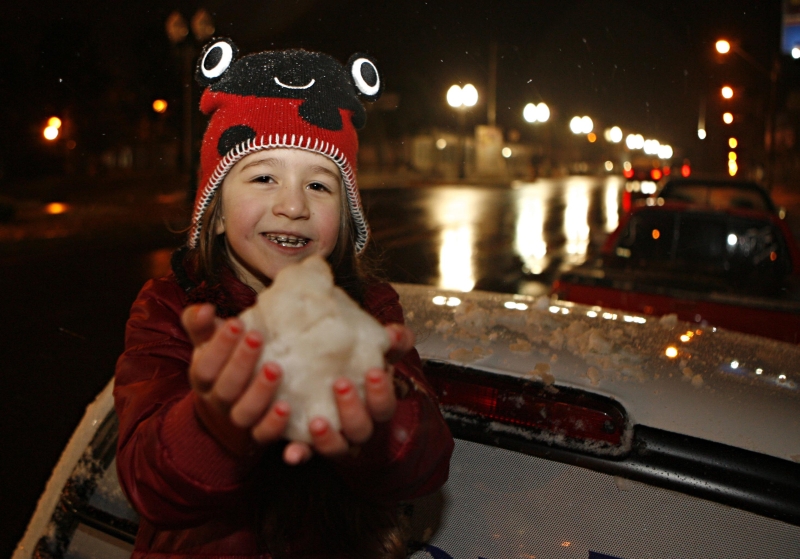 Criança brinca com neve acumulada sobre os carros em Palmas | Josué Teixeira/Gazeta do Povo