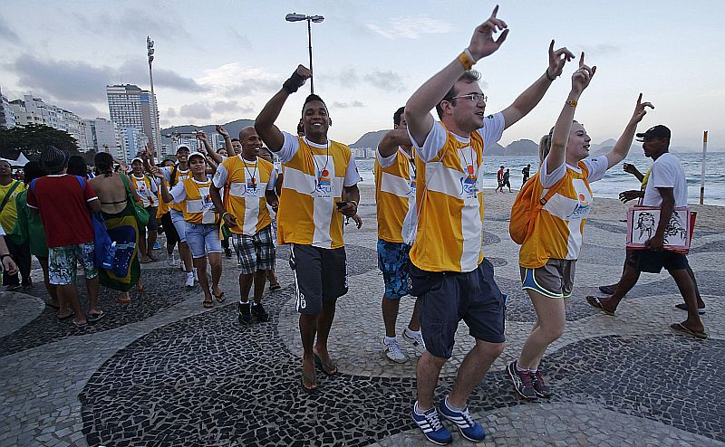 Peregrinos festejam na praia de Copacabana, no Rio, a vinda do papa Francisco para a Jornada Mundial da Juventude | REUTERS/Sergio Moraes