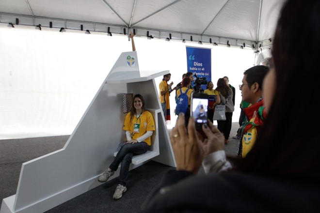 Peregrina posa para foto no local onde o papa Francisco ouviu a confissão dos jovens | 