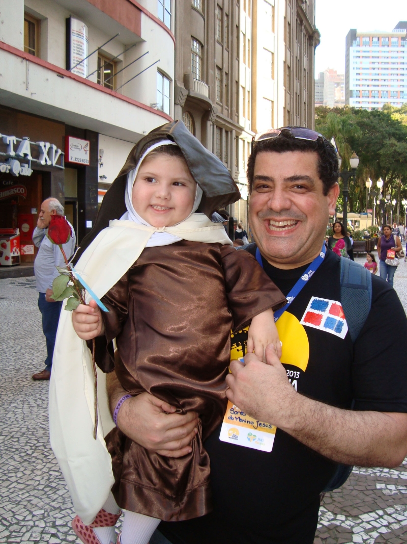 Veja só que graça essa mini-Santa Terezinha no colo do coordenador da Jornada Mundial da Juventude da Paróquia Santa Terezinha de Curitiba, Rupérsio Cançado. A coluna flagrou os dois ontem em plena Boca Maldita, junto com um grupo de paroquianas | Reinaldo Bessa