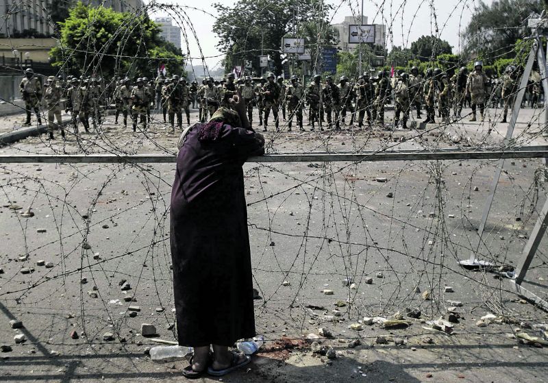 Apoiadora do ex-presidente Mursi aparece diante de soldados no subúrbio do Cairo: violência complica o processo de transição | Amr Abdallah Dalsh/Reuters