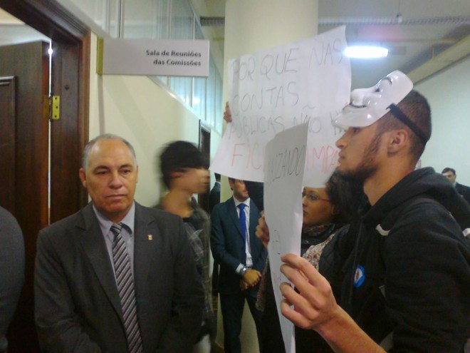 Com cartazes e gritando palavras de ordem, um grupo de quatro manifestantes entrou na sala onde os candidatos eram ouvidos |