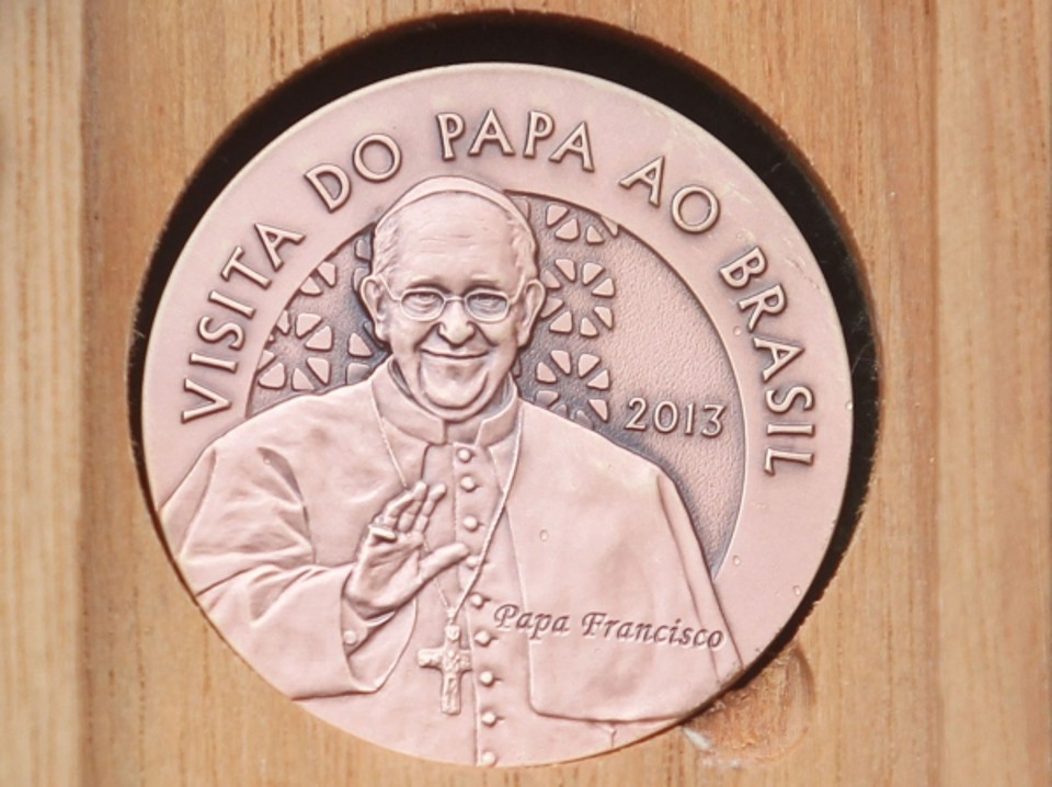 Casa da Moeda lança medalhas comemorativas: Três medalhas comemorativas da vinda do papa Francisco ao Brasil em bronze, prata e ouro foram entregues ontem pela Casa da Moeda ao cardeal Tarcisio Bertoni, secretário de estado do Vaticano, na residência Assunção, no Sumaré, onde o pontífice está hospedado. O papa não compareceu à cerimônia, transferida do Cristo Redentor para o Sumaré por causa da chuva. As medalhas estão à venda no site da Casa da Moeda. A de bronze custa R$ 45, a de prata, R$ 230 e a de ouro tem preço sob consulta. A entrega das medalhas teve um coral de idosos da Igreja Nossa Senhora da Paz, em Ipanema. Foi uma pena o papa não ter podido participar, mas foi muito bonito. A Casa da Moeda participa de todas as datas importantes para o país, disse o presidente em exercício da instituição, Marcone Leal. (Agência Estado) | Marcos de Paula/Estadão Conteúdo