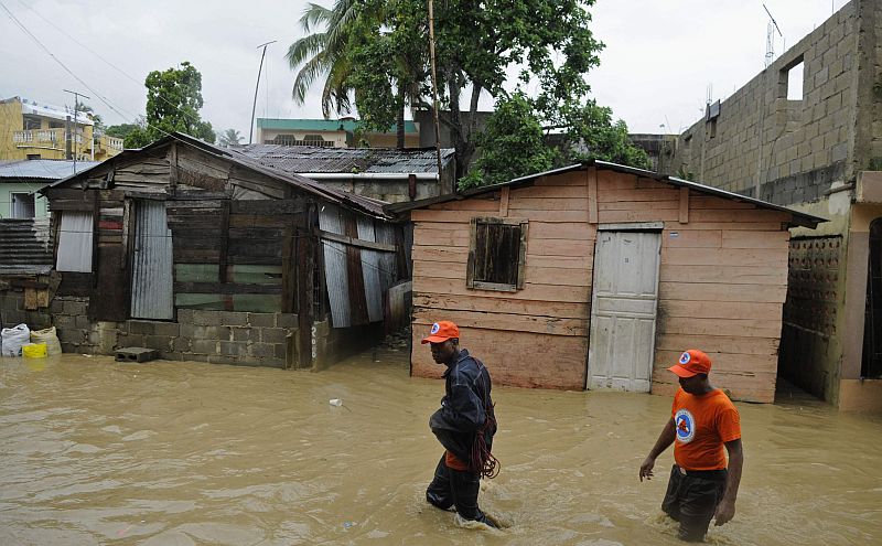 Homens percorrem área alagada em Santo Domingo, na República Dominicana, durante a passagem da tempestade tropical Chantal | REUTERS/Ricardo Rojas