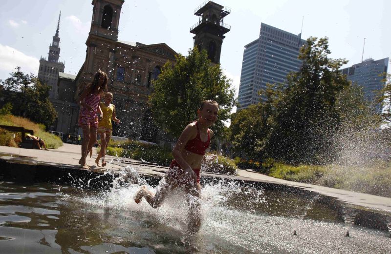 Meninas brincam numa fonte no centro de Varsóvia, na Polônia | Kacper Pempel/Reuters