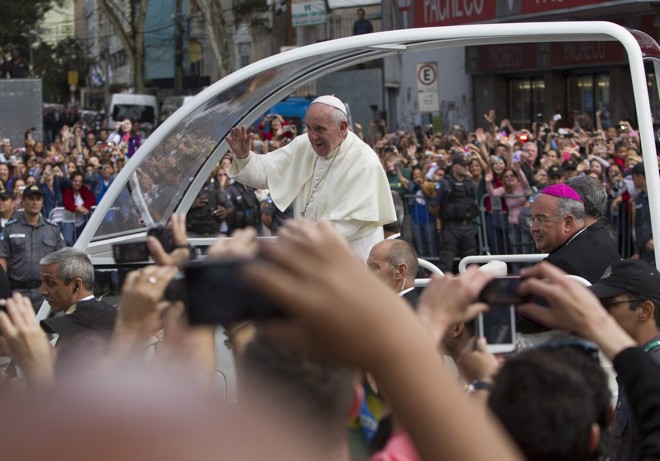 Francisco acena para a multidão que acompanhava o trajeto feito de papamóvel | 