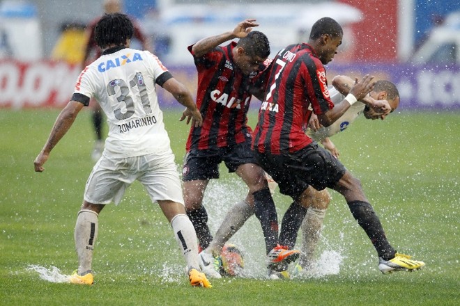 Jogadores disputa jogada no impraticável gramado da Vila. Chuva atrapalhou o duelo | 