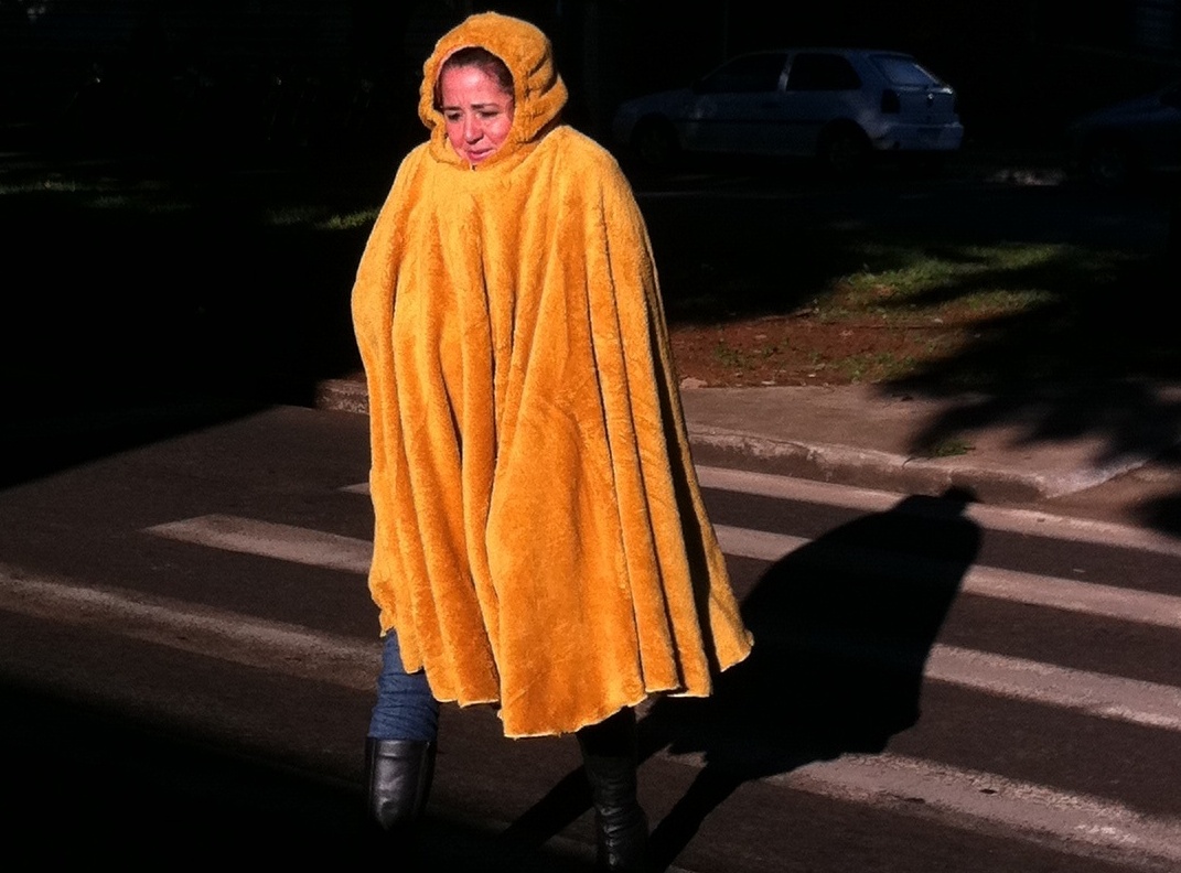 Na av. Independência, uma pedestre investiu em um poncho para enfrentar a manhã gelada | Karen Faccin / Gazeta Maringá