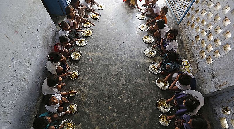 Crianças almoçam em escola primária na vila de Brahimpur, na Índia. Mais de 20 crianças morreram intoxicadas por pesticida que contaminou a merenda escolar | REUTERS/Adnan Abidi