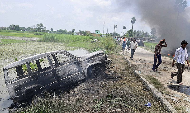 Veículo queimado em Chapra, na Índia, após protestos que começaram depois do anúncio de que crianças morreram contaminadas com a merenda escolar | REUTERS/Stringer