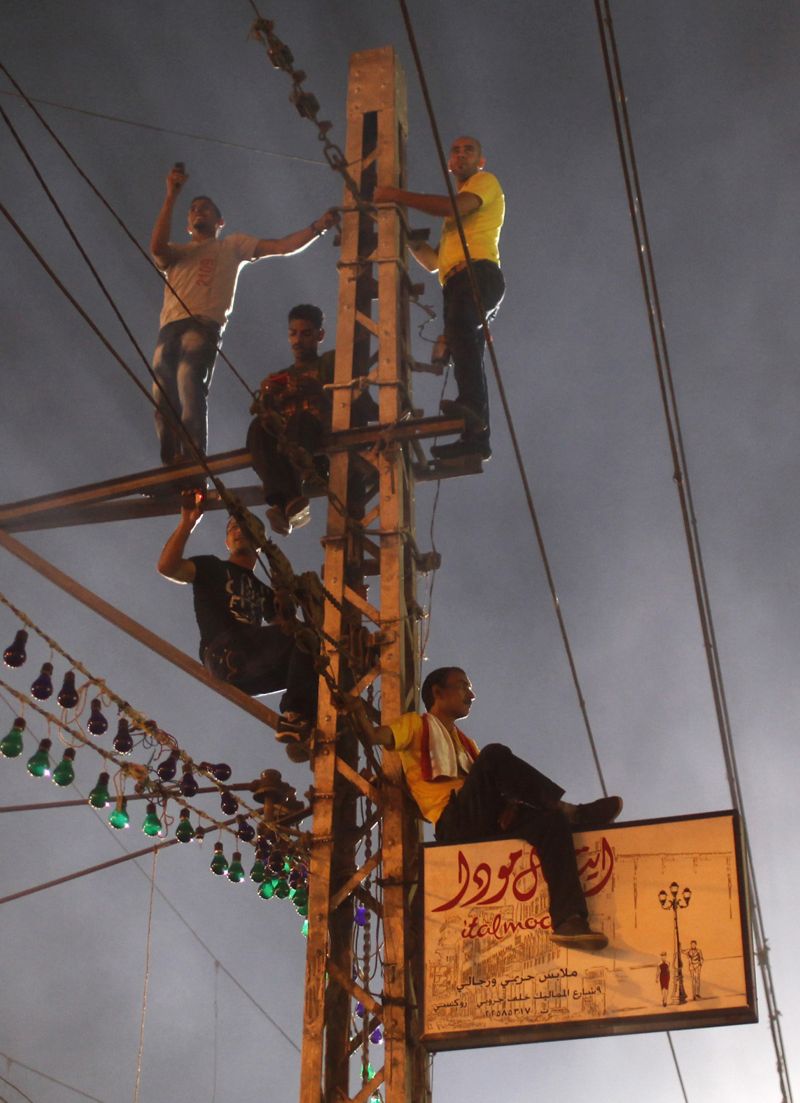 Manifestantes pró-militares em um poste de luz, no Cairo | Asmaa Waguih/Reuters