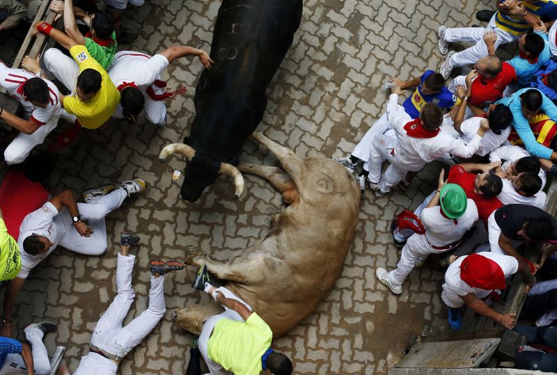 Pessoas pulam sobre um touro caído durante a Festa de São Firmino, em Pamplona, na Espanha | REUTERS/Susana Vera