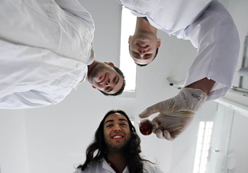 Os pesquisadores da UEPG Fábio, Rodolfo e Alan mostram frasco com óxido de grafeno | Josué Teixeira/ Gazeta do Povo