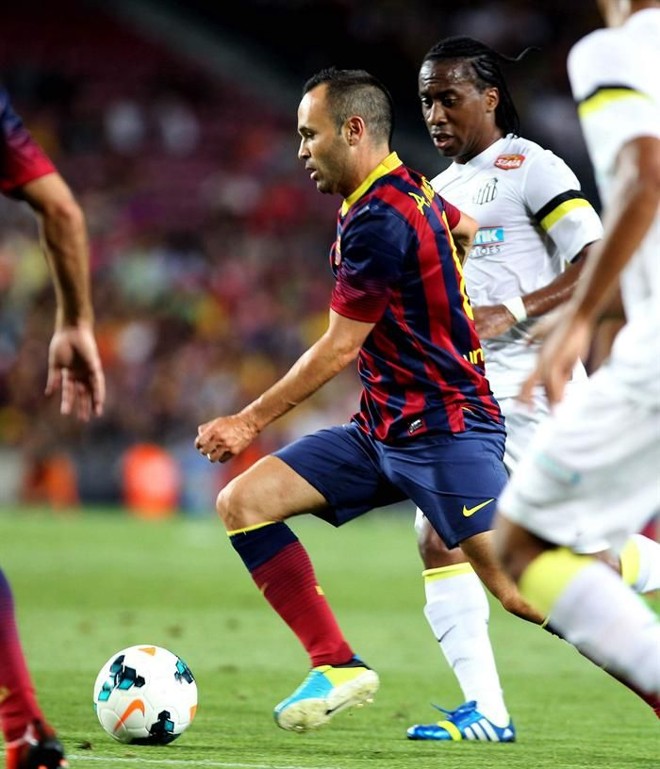 Iniesta tenta passar pela marcação do santista Arouca |