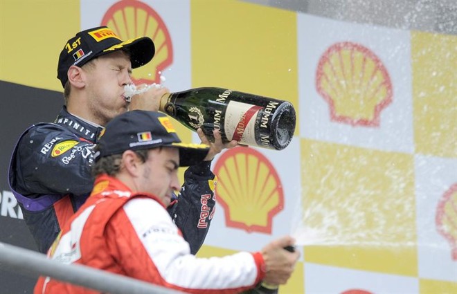 O piloto Fernando Alonso, da Ferrari (ao centro), e Sebastian Vettel, da Red Bull, comemoram o resultado da prova na Bélgica | 