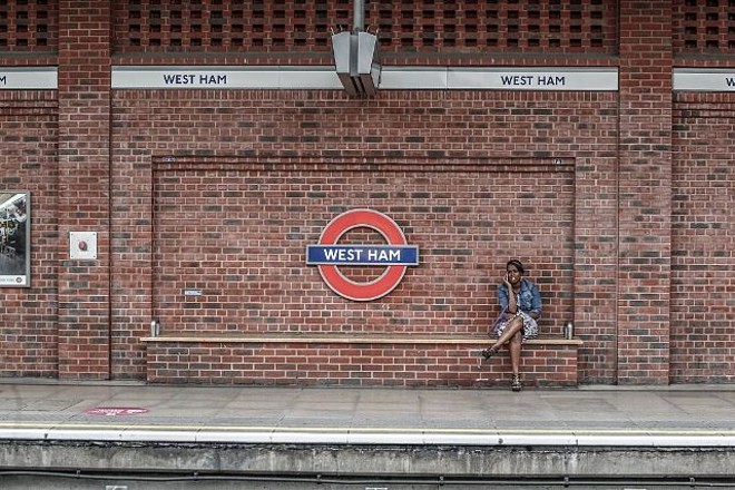 Mulher espera na estação West Ham |