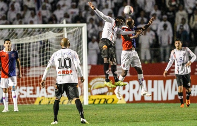Reinaldo em disputa de bola com os zagueiros paranistas | Brunno Covello / Gazeta do Povo