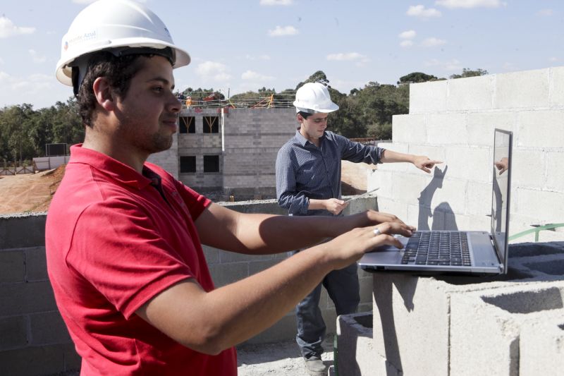 O engenheiro Tiago Francisco Campestrini e Everton Souza, que o auxilia no cadastro das informações. Na obra, modelo no computador ajuda a prever incompatibilidades | André Rodrigues/ Gazeta do Povo