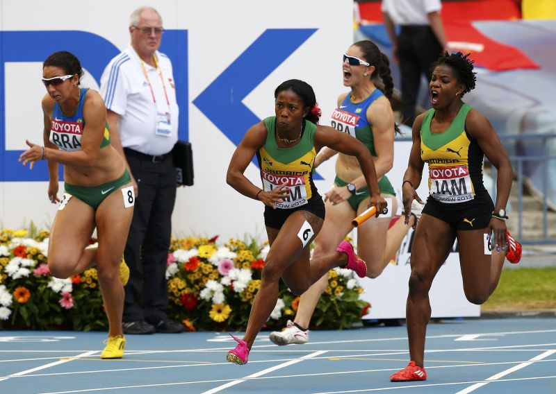 Jamaicana Shelly-Ann Fraser-Pryce (centro) recebe o bastão de Schillonie Calvert, enquanto a brasileira Franciela Krasucki (à esquerda) derruba o bastão que seria recebido por Vanda Gomes | REUTERS/Dominic Ebenbichler