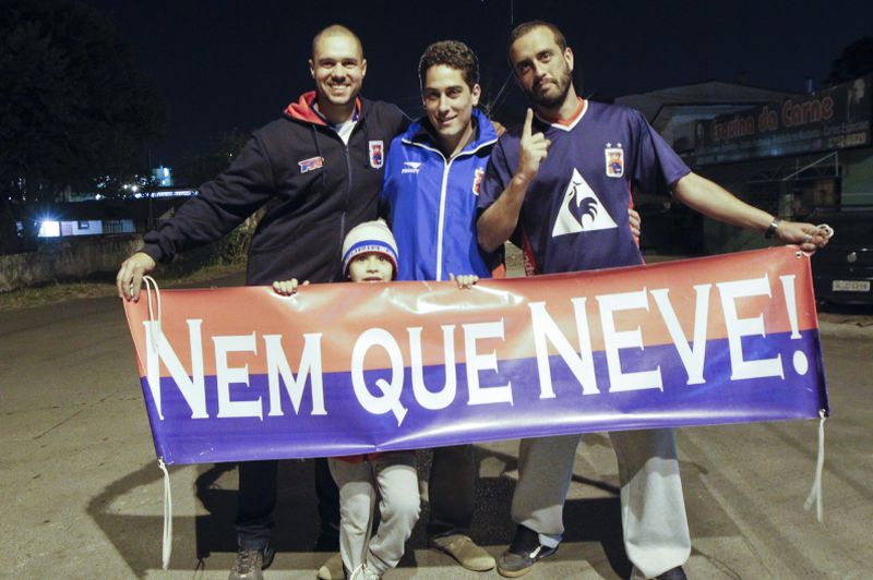 Jeson e os amigos Luan, Lucas Alvarenga e Rafael com a faixa que promete o apoio incondicional ao Paraná: exemplo de paixão pelo Tricolor | Daniel Castellano/ Gazeta do Povo