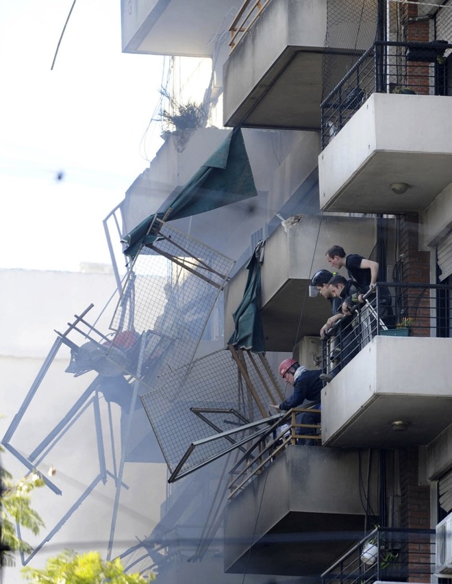 Moradores observam o trabalho dos bombeiros | Reuters/Juan Giovacchini