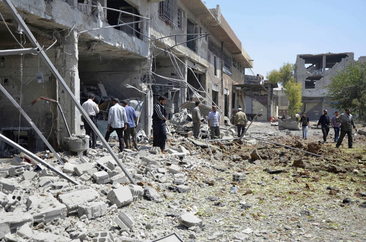 Homens inspecionam um prédio que teria sido atingido por um ataque aéreo de forças leais a Bashar al-Assad em Duma, nos arredores de Damasco | Reuters/Bassam Khabieh