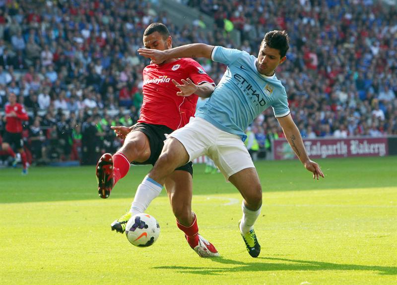 Steven Caulker (à esquerda), do Cardiff City, e Sergio Aguero do Manchester City disputam jogada em confronto pelo Campeonato Inglês | EFE/EPA/GEOFF CADDICK