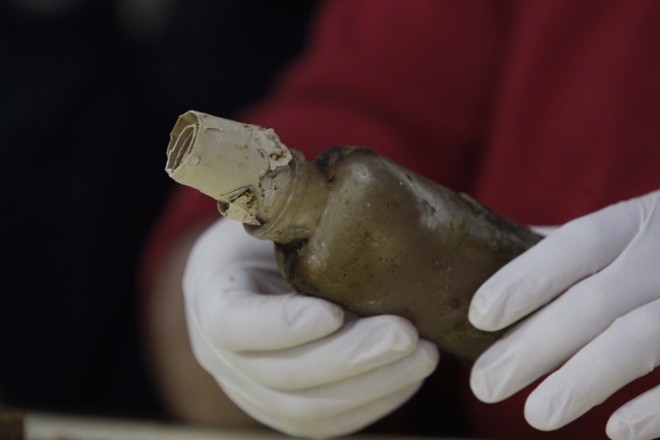 Técnico remove o manuscrito de dentro da garrafa |