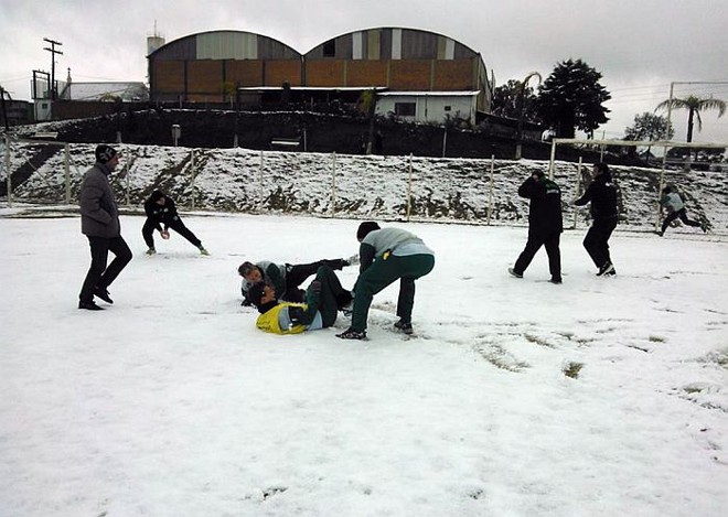 Jogadores do Juventude brincam no gramado coberto de neve em Caxias do Sul |