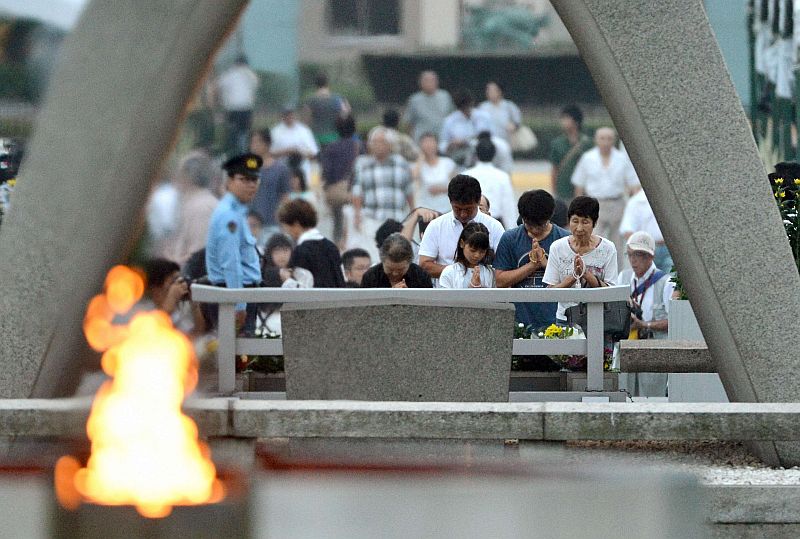 Pessoas homenageiam as vítimas da bomba atômica de Hiroshima, no Japão, diante de memorial aos mortos | REUTERS/Kyodo