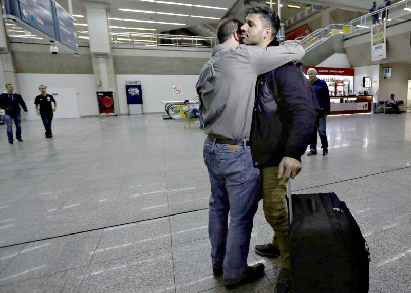 Jornalista Glenn Greenwald (à esq.) abraça o namorado David Miranda no aeroporto internacional do Galeão, no Rio de Janeiro | Ricardo Moraes/Reuters